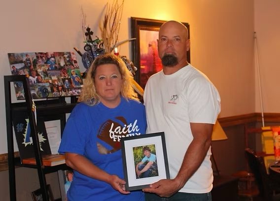 David and Lisa Schemm holding a photo of their son Luke